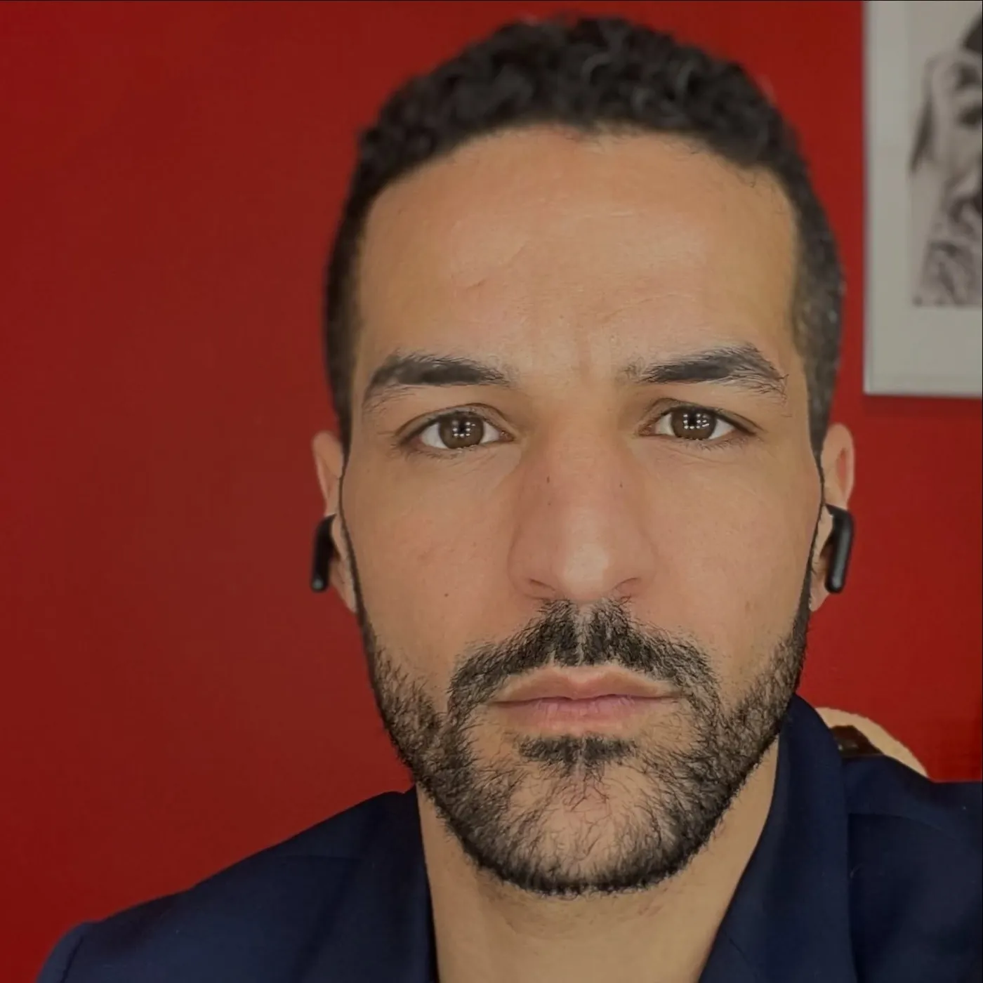 Omar Meftah, portrait en gros plan sur fond rouge (portrait 2026)