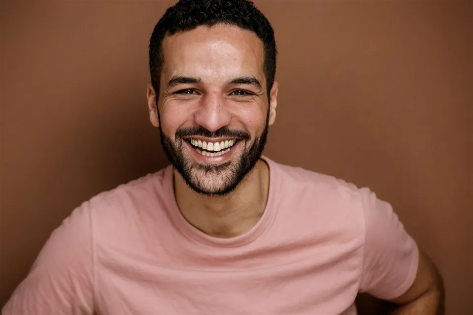 Omar Meftah, portrait souriant en t-shirt rose