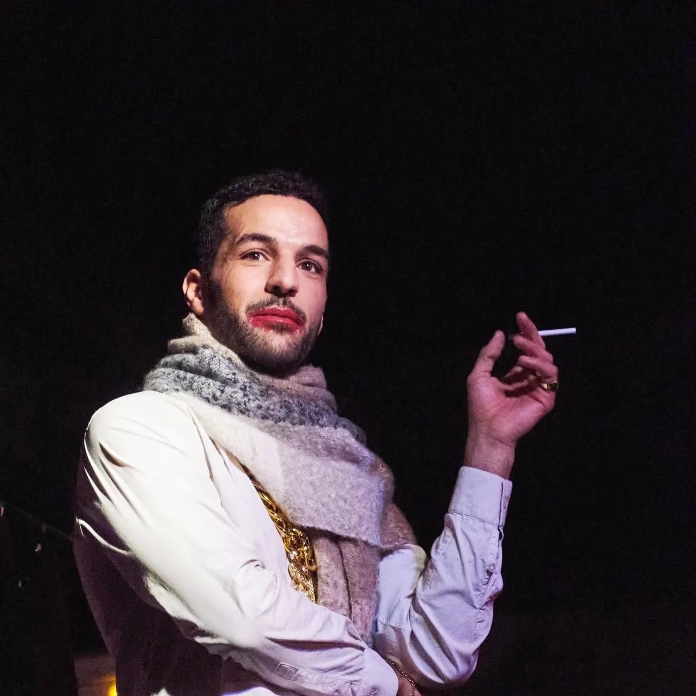 Omar Meftah sur scène à l'Angelus, écharpe et cigarette à la main